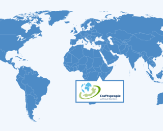 Das Bild zeigt eine einfache Weltkarte in Blau mit dem Logo von "Craftspeople without Borders" in der Mitte, das Zusammenarbeit symbolisiert.