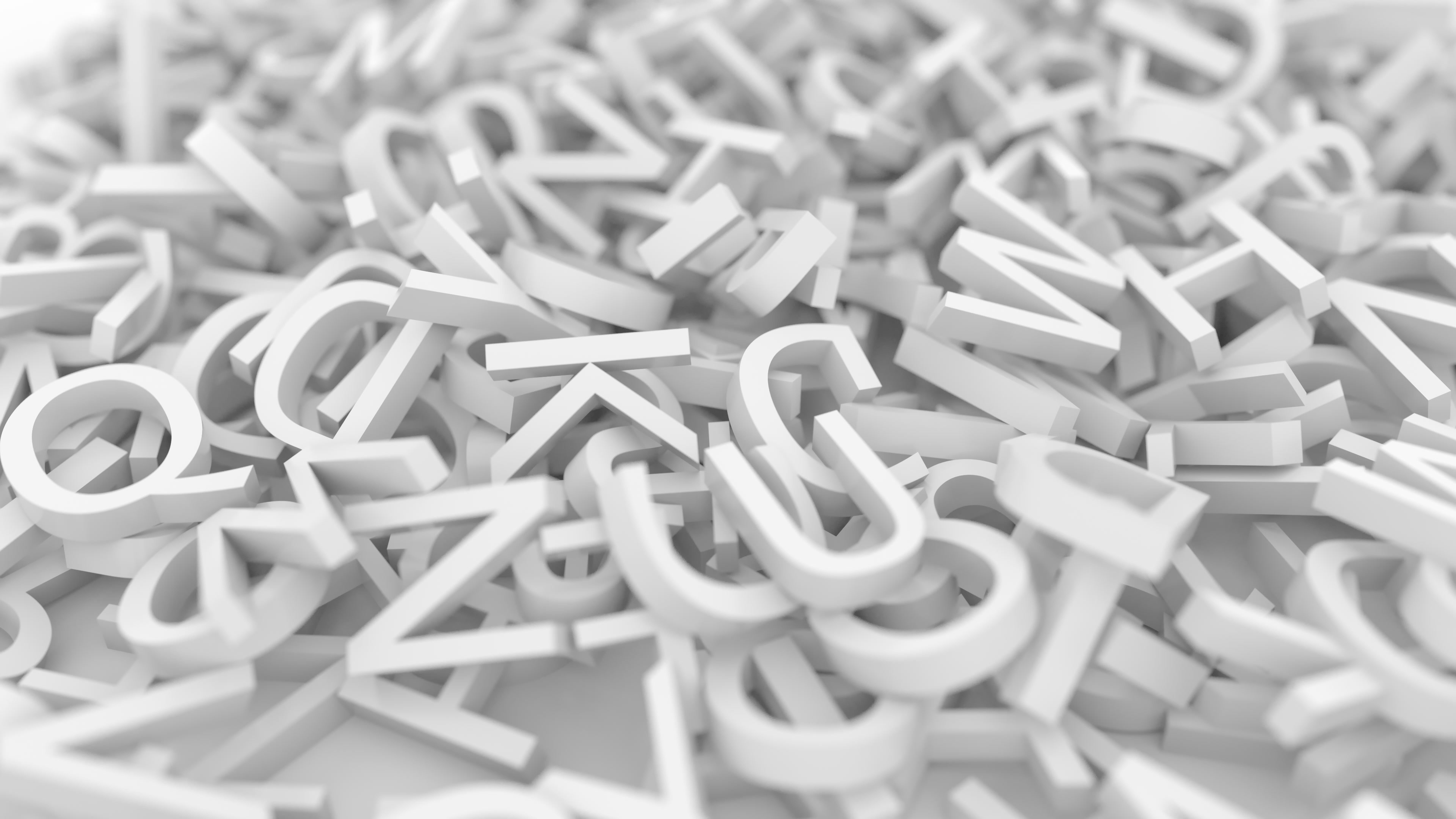 Das Bild zeigt eine chaotische Ansammlung von weißen Buchstaben, die zufällig und übereinander gestapelt liegen, auf einem hellen Untergrund.