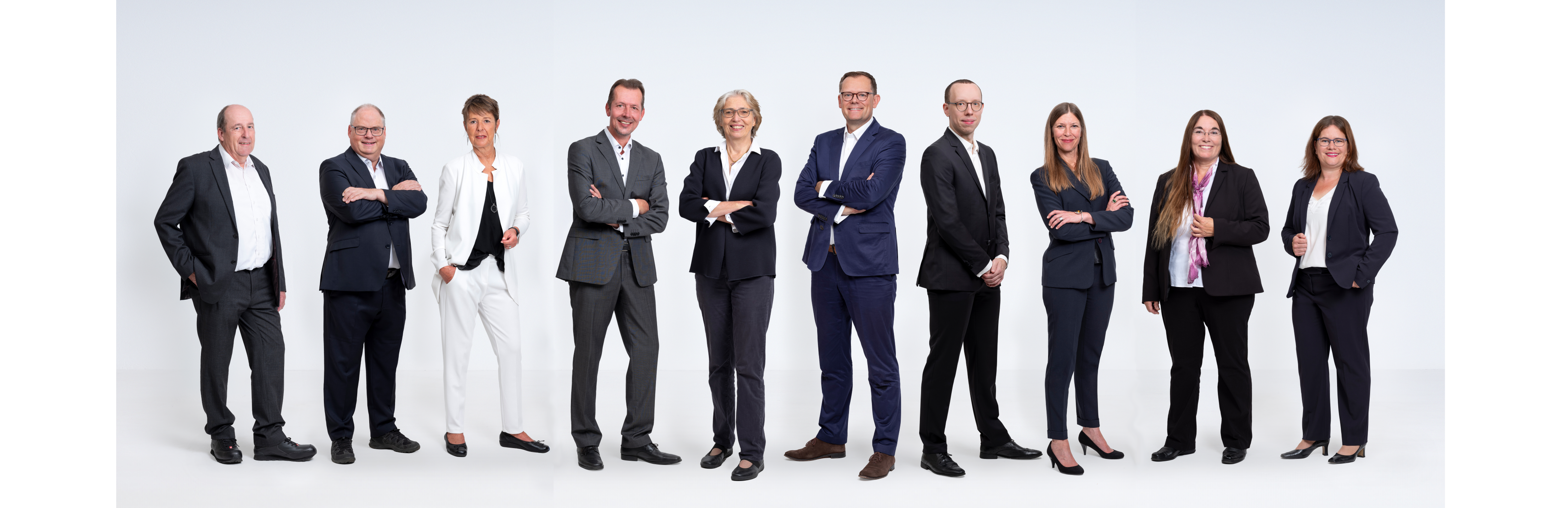 Das Bild zeigt eine Gruppe von zehn Personen in formeller Kleidung, die in einer Reihe stehen und in die Kamera lächeln. Dies sind die Berater der HWK Frankfurt-Rhein-Main.